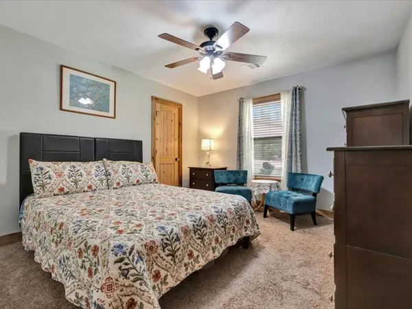 a bedroom with a large bed couch and a window