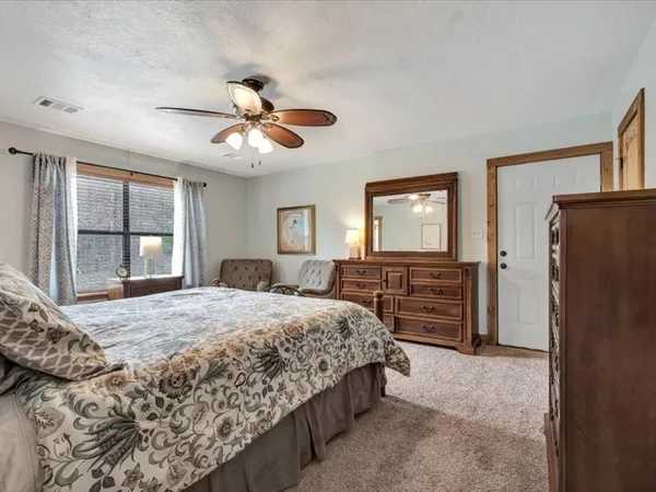 a bedroom with a bed dresser and a window