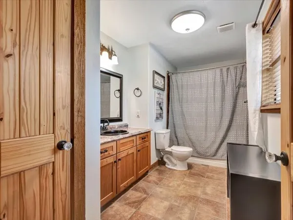 a spacious bathroom with a toilet a sink and a mirror