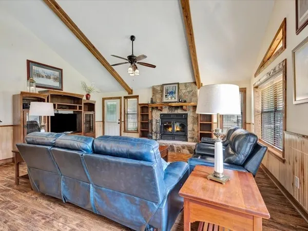 a living room with furniture a fireplace and a flat screen tv