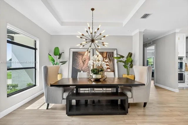 a kitchen with stainless steel appliances a table chairs and white cabinets