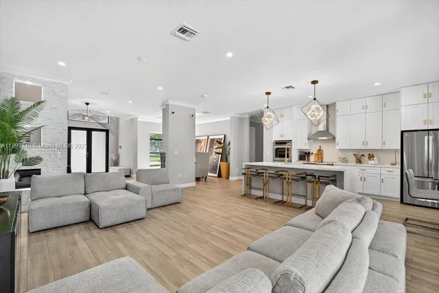 a bedroom with a bed and dresser with wooden floor