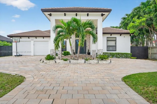 a front view of house with a yard and potted plants
