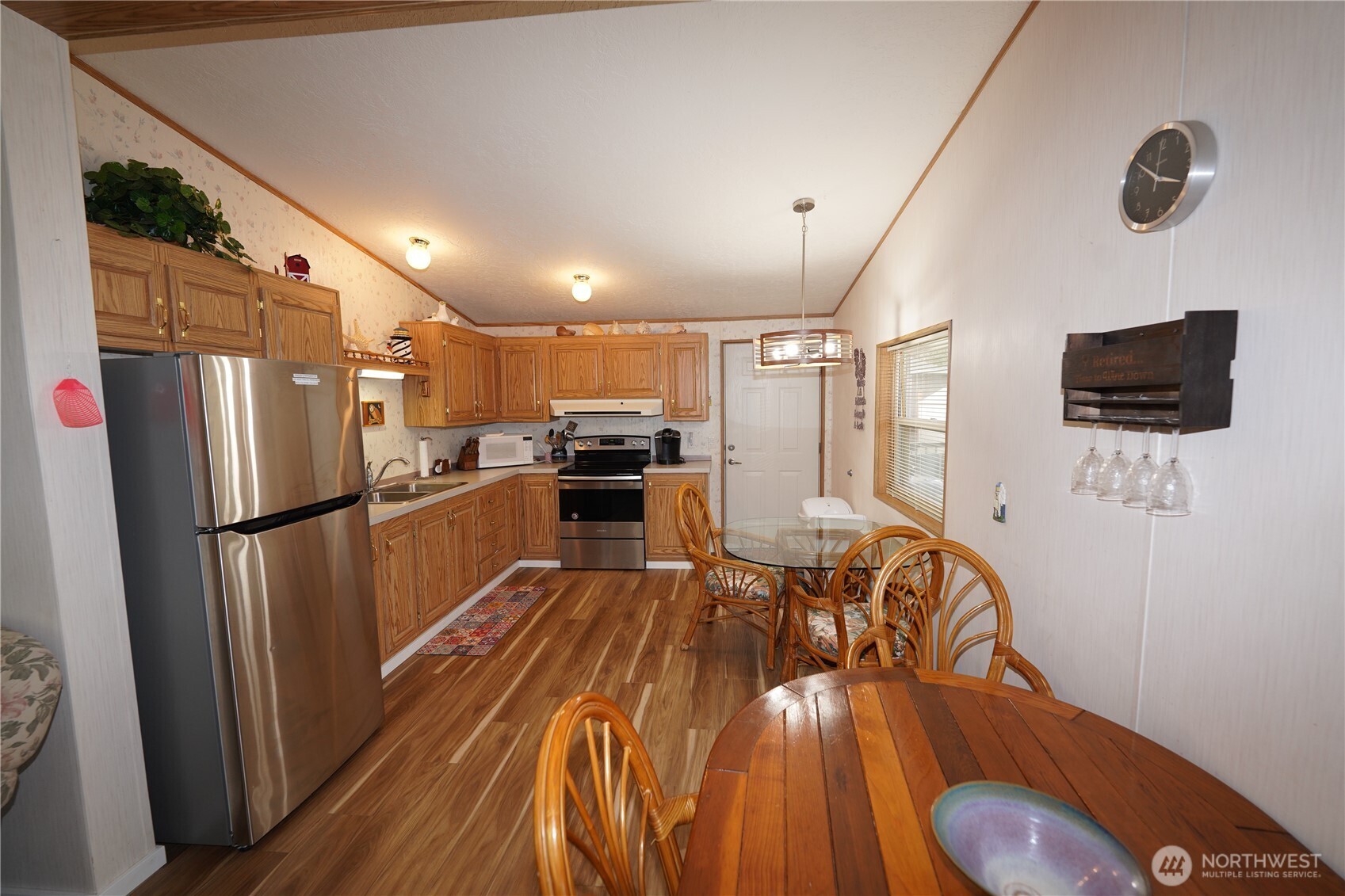 27509 Q Lane Ocean Park, WA 98640 - Photo 7 of 20 a kitchen with stainless steel appliances a refrigerator a stove a microwave oven with a dining table and chairs