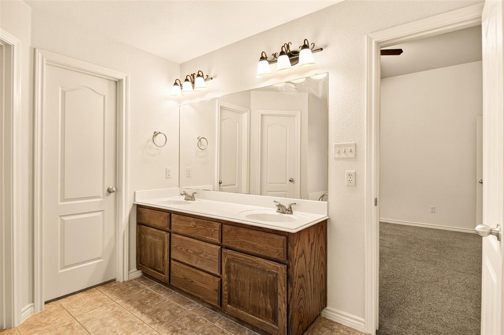 2105 Ridgewood Drive Bridgeport, TX 76426 - Photo 20 of 27 Double vanity with wood-finish cabinetry, white countertop, and dual sinks