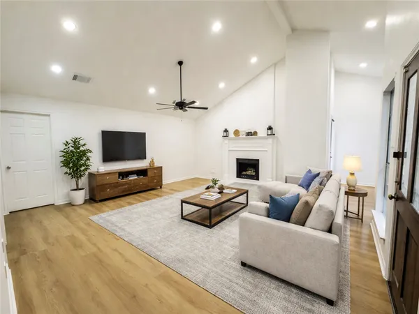 a living room with furniture a fireplace and a flat screen tv