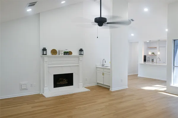 a view of an empty room with a fireplace and a window