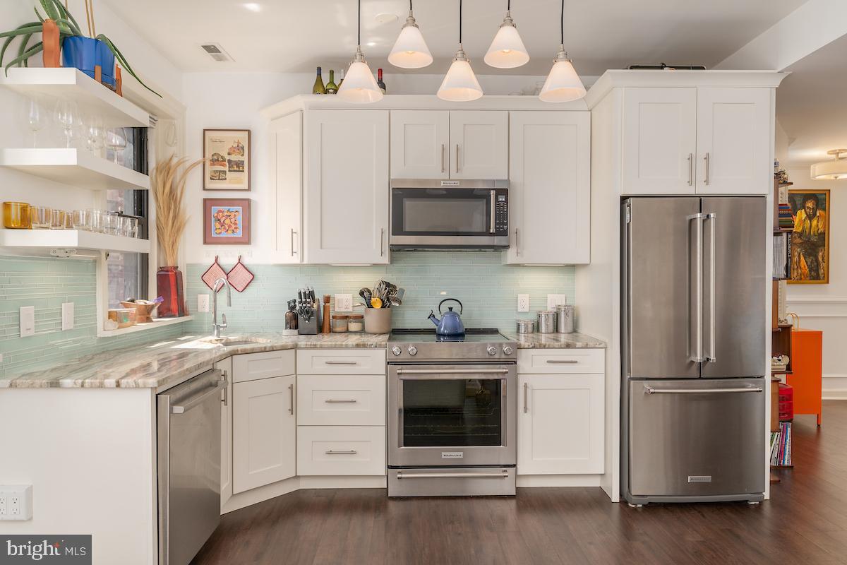 1930 18th Street Northwest, Unit 32 Washington, DC 20009 - Photo 1 of 17 a kitchen with cabinets stainless steel appliances and wooden floor