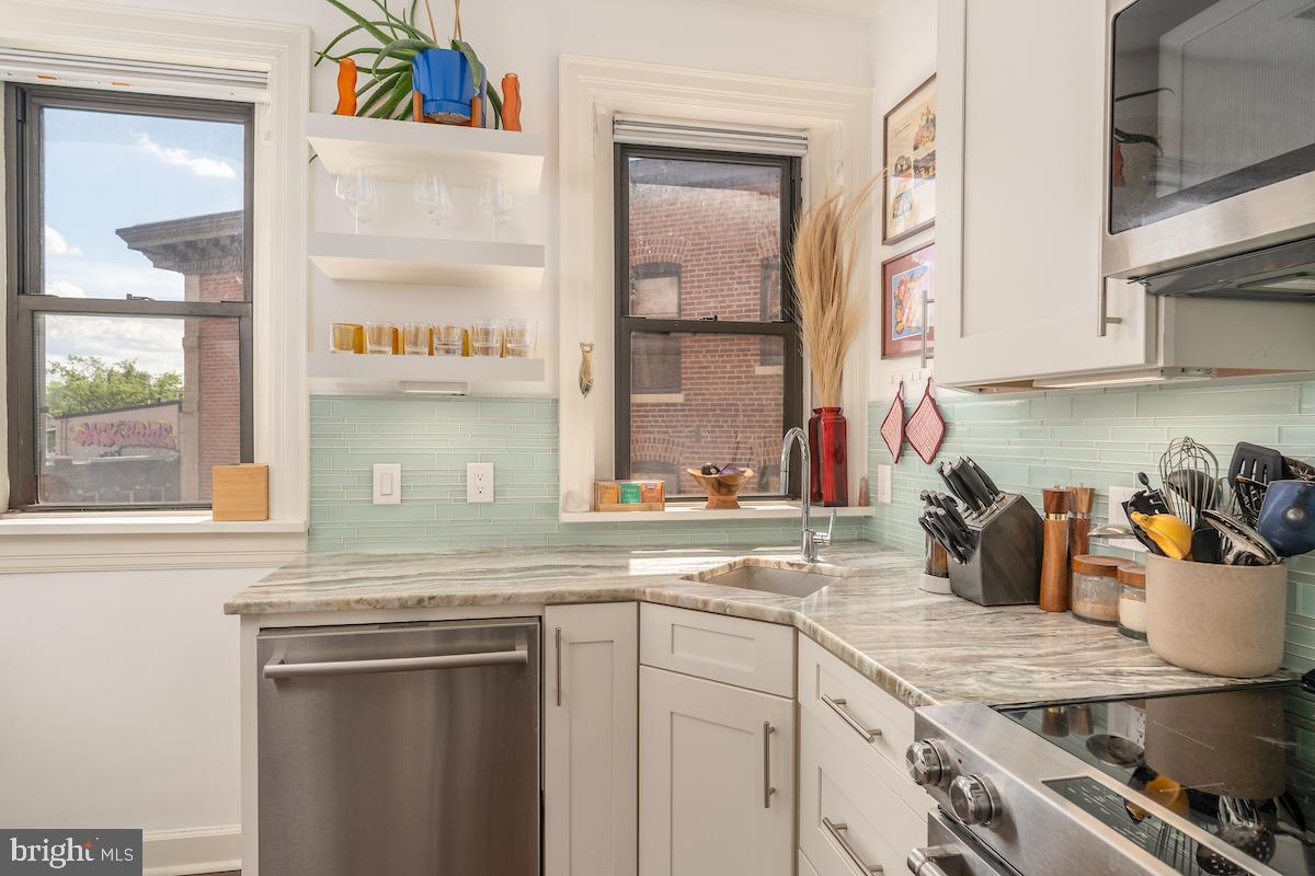 1930 18th Street Northwest, Unit 32 Washington, DC 20009 - Photo 5 of 17 a kitchen with stainless steel appliances granite countertop a sink and a stove