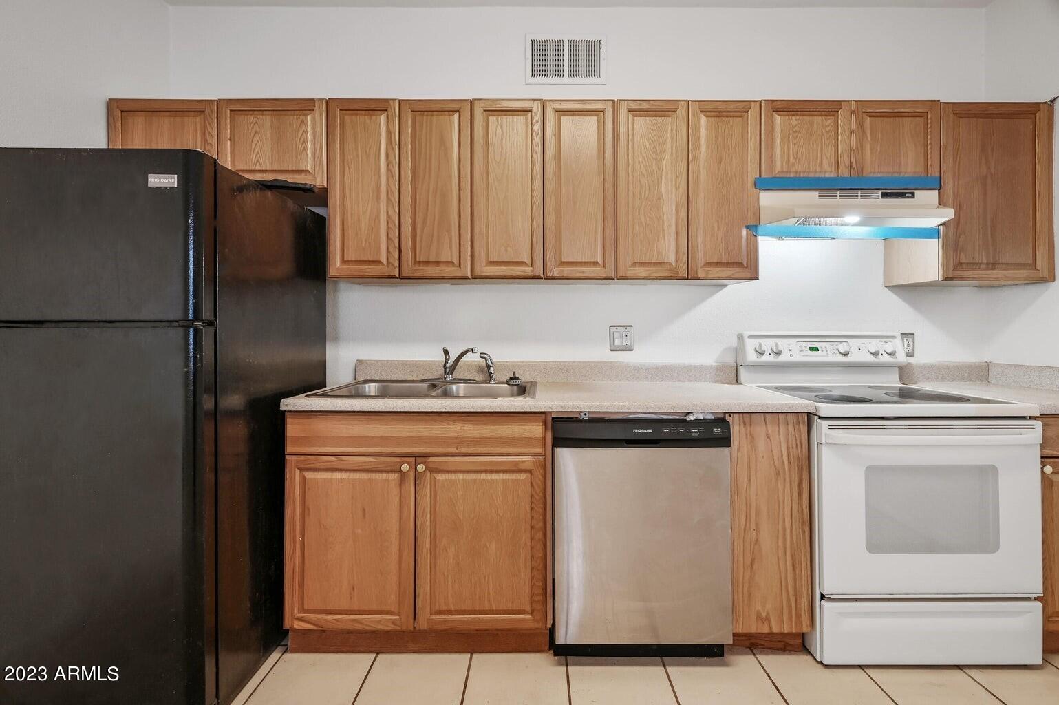 5327 East Taylor Street, Unit A Phoenix, AZ 85008 - Photo 6 of 11 a kitchen with stainless steel appliances granite countertop a refrigerator a sink and white cabinets