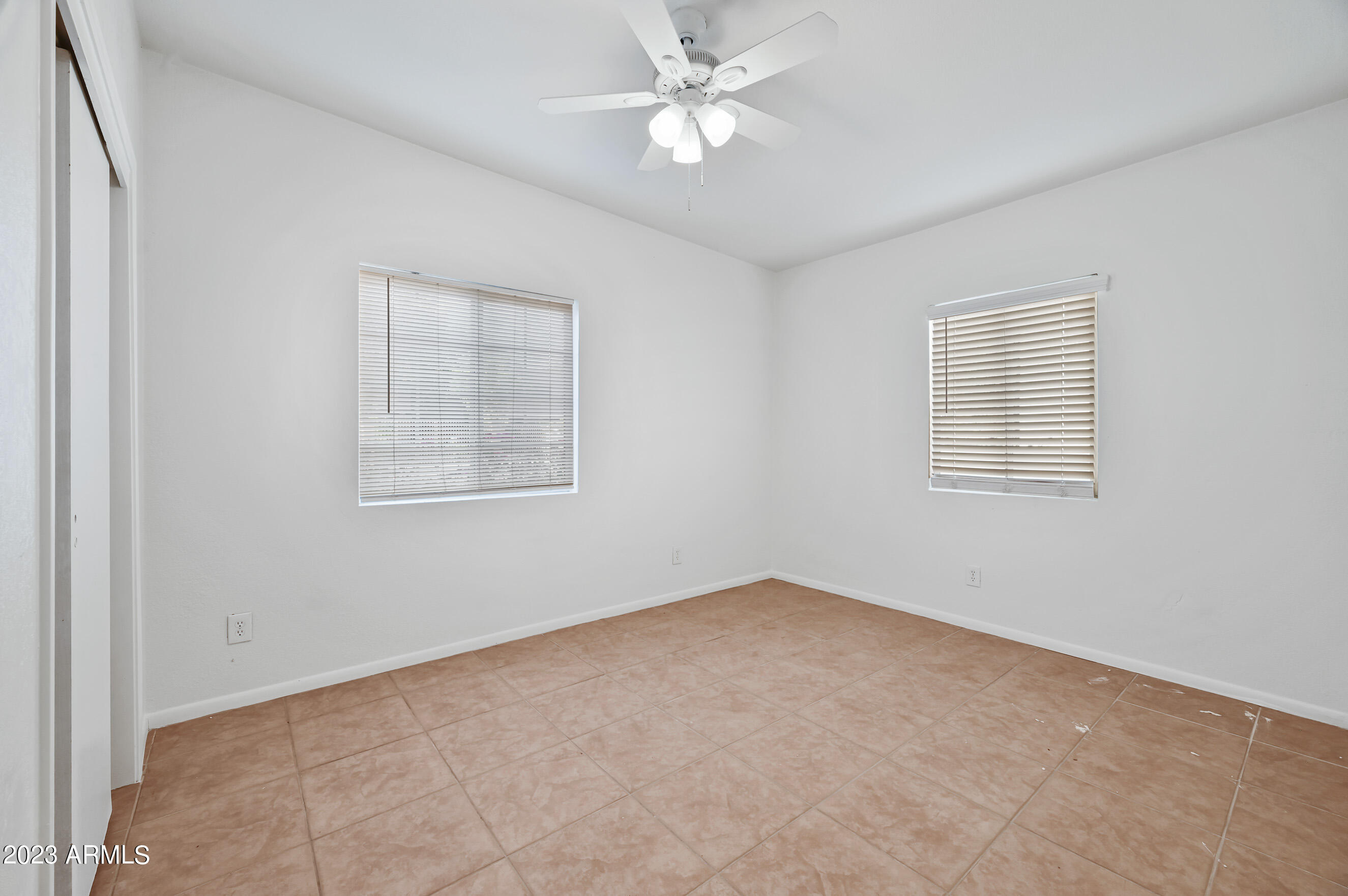 5327 East Taylor Street, Unit A Phoenix, AZ 85008 - Photo 8 of 11 an empty room with a window and ceiling fan