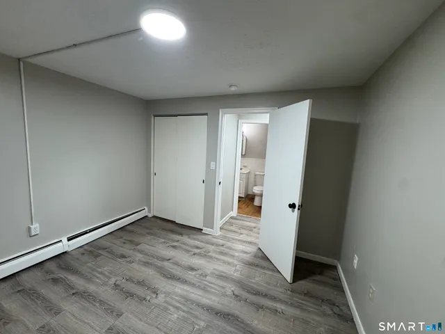 an empty room with wooden floor and entrance