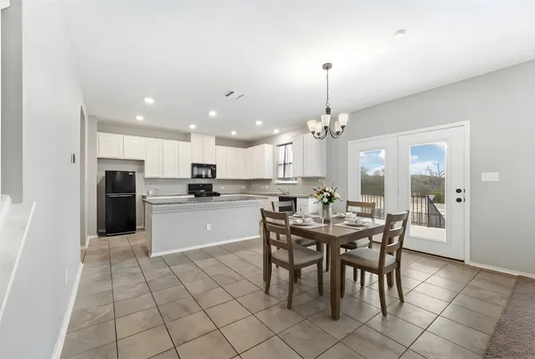 a kitchen with stainless steel appliances kitchen island granite countertop a dining table chairs and granite counter tops