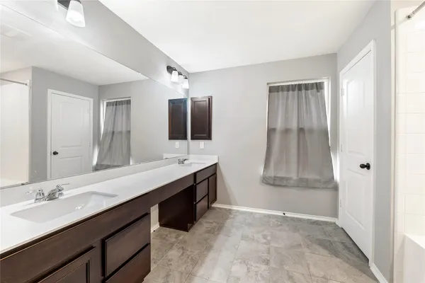 a bathroom with double vanity sinks and a mirror