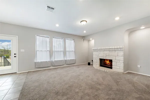 an empty room with fireplace and windows