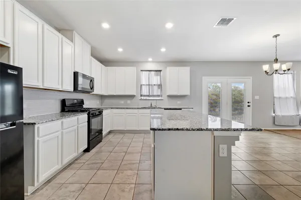 a kitchen with stainless steel appliances granite countertop a sink and cabinets
