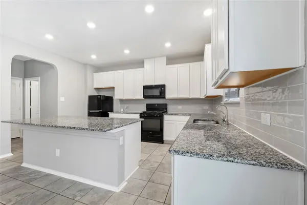 a kitchen with stainless steel appliances granite countertop a sink and a stove