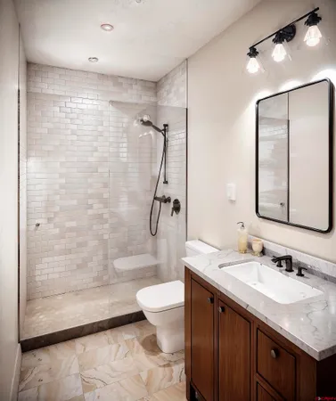 a bathroom with a granite countertop sink a toilet and shower