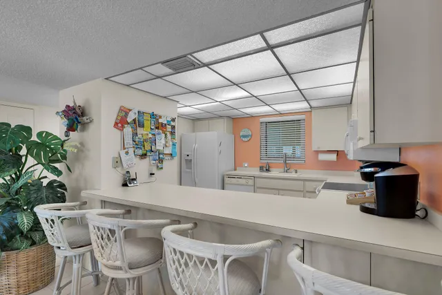a kitchen with stainless steel appliances granite countertop a table and chairs in it