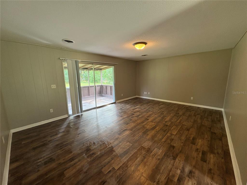 1236 Northeast 22nd Street Ocala, FL 34470 - Photo 21 of 42 an empty room with wooden floor and windows