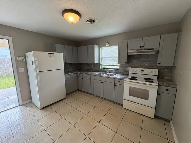 a kitchen with a sink cabinets and window