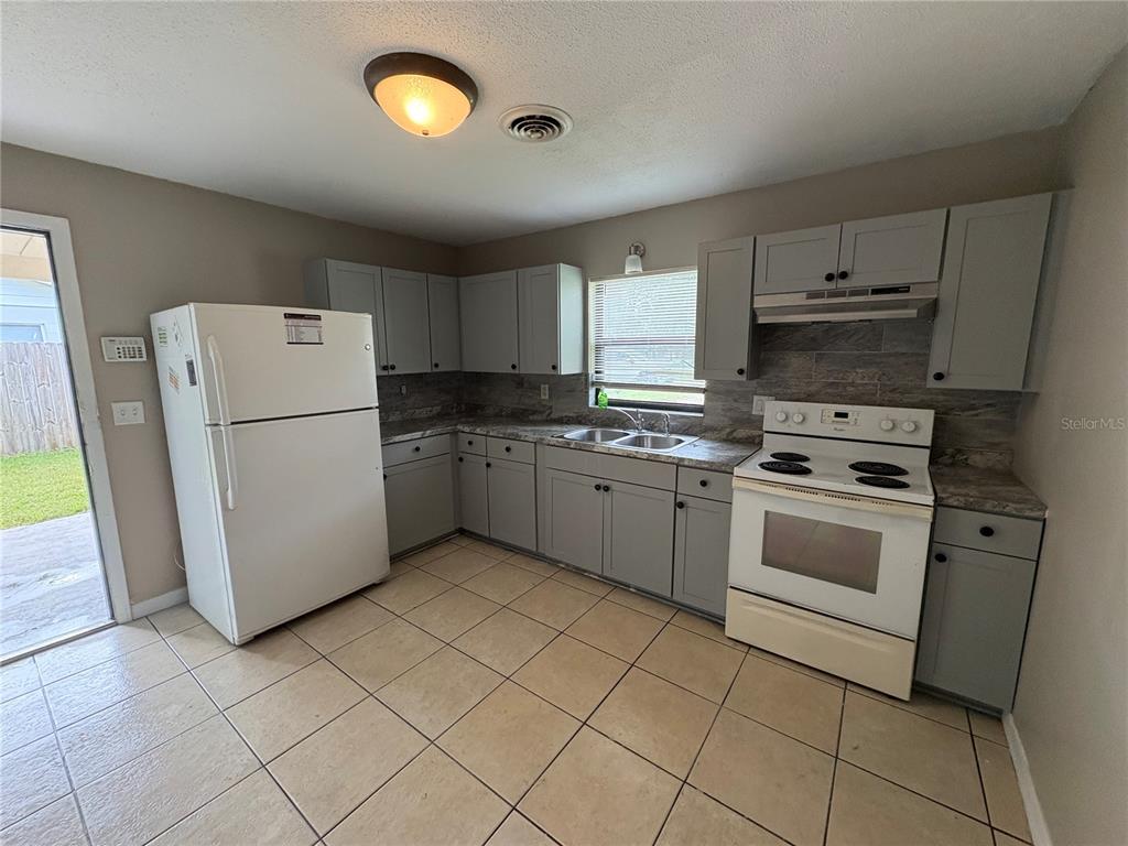 1236 Northeast 22nd Street Ocala, FL 34470 - Photo 36 of 42 a kitchen with cabinets and white appliances