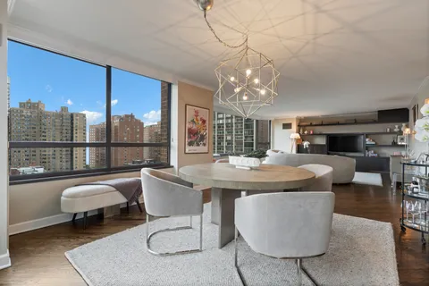a dining room with furniture a rug and a chandelier