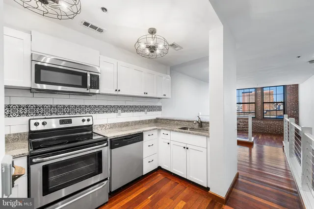 a kitchen with granite countertop a stove and cabinets