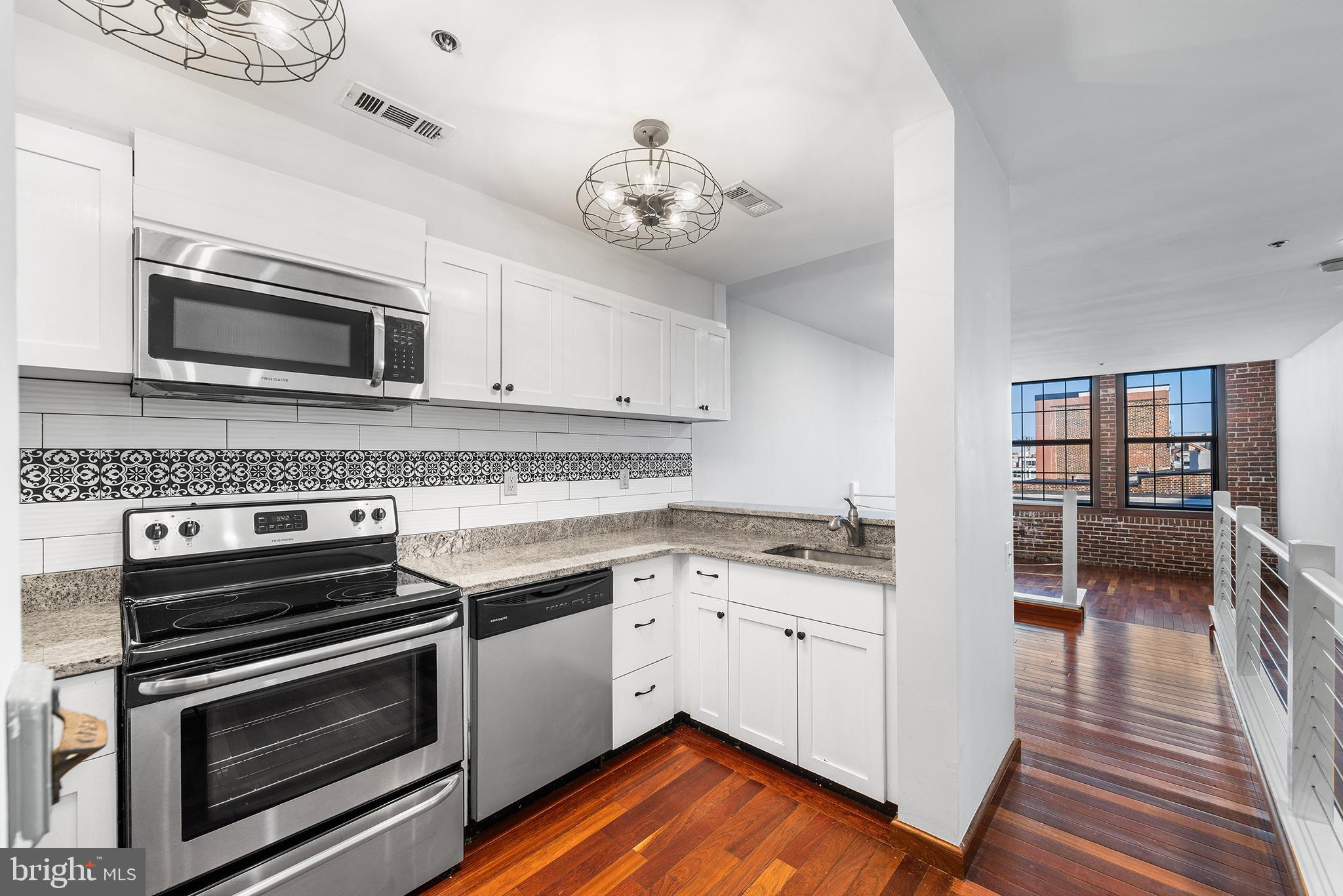 315 New Street, Unit 614 Philadelphia, PA 19106 - Photo 3 of 32 a kitchen with granite countertop a stove and cabinets