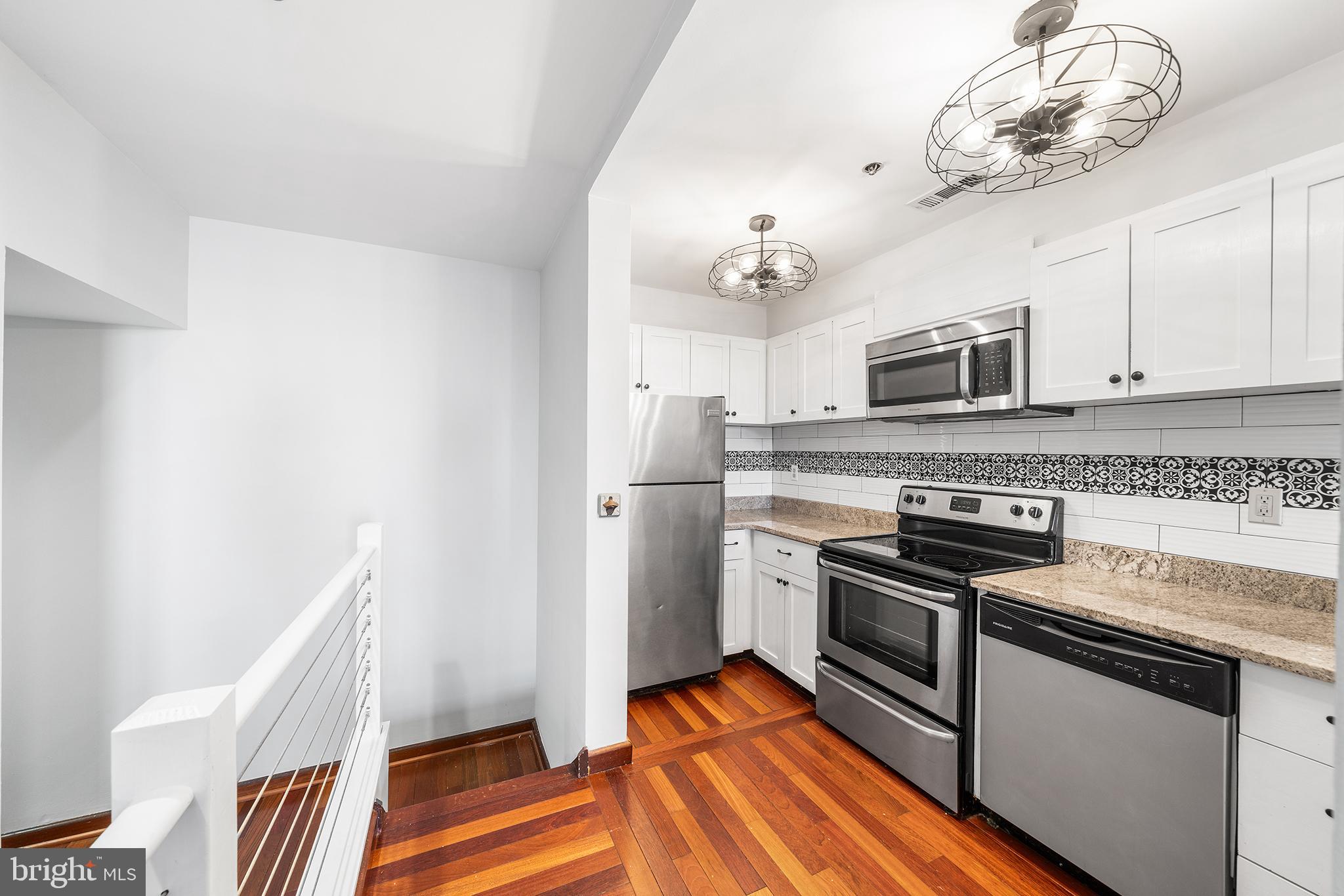 315 New Street, Unit 614 Philadelphia, PA 19106 - Photo 8 of 32 a kitchen with stainless steel appliances a stove microwave and a refrigerator
