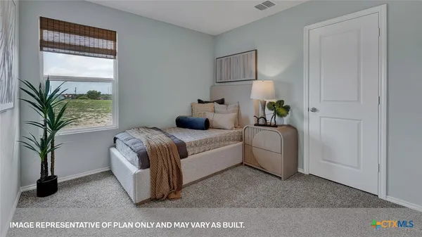 a bedroom with a bed and a potted plant