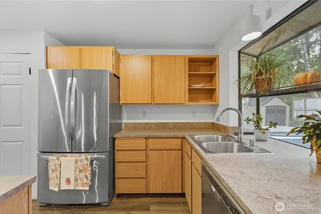 a kitchen with stainless steel appliances granite countertop a refrigerator and a sink