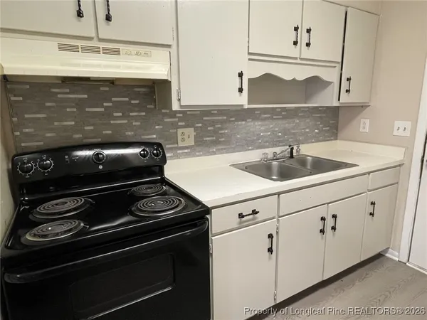a kitchen with granite countertop white cabinets and appliances