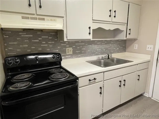 a kitchen with granite countertop white cabinets and appliances