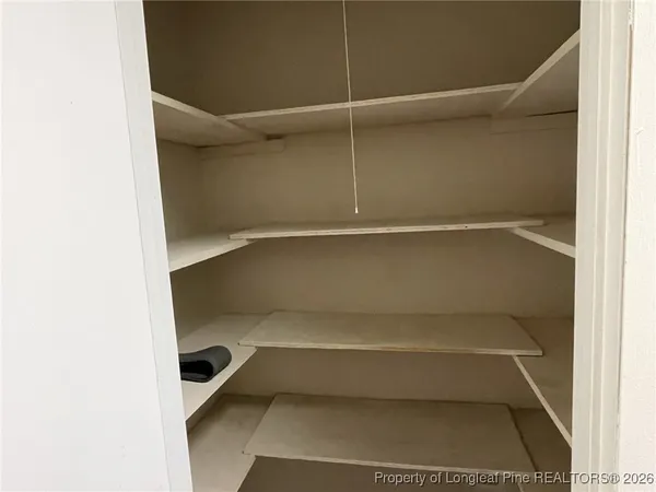 a view of walk in closet with empty racks