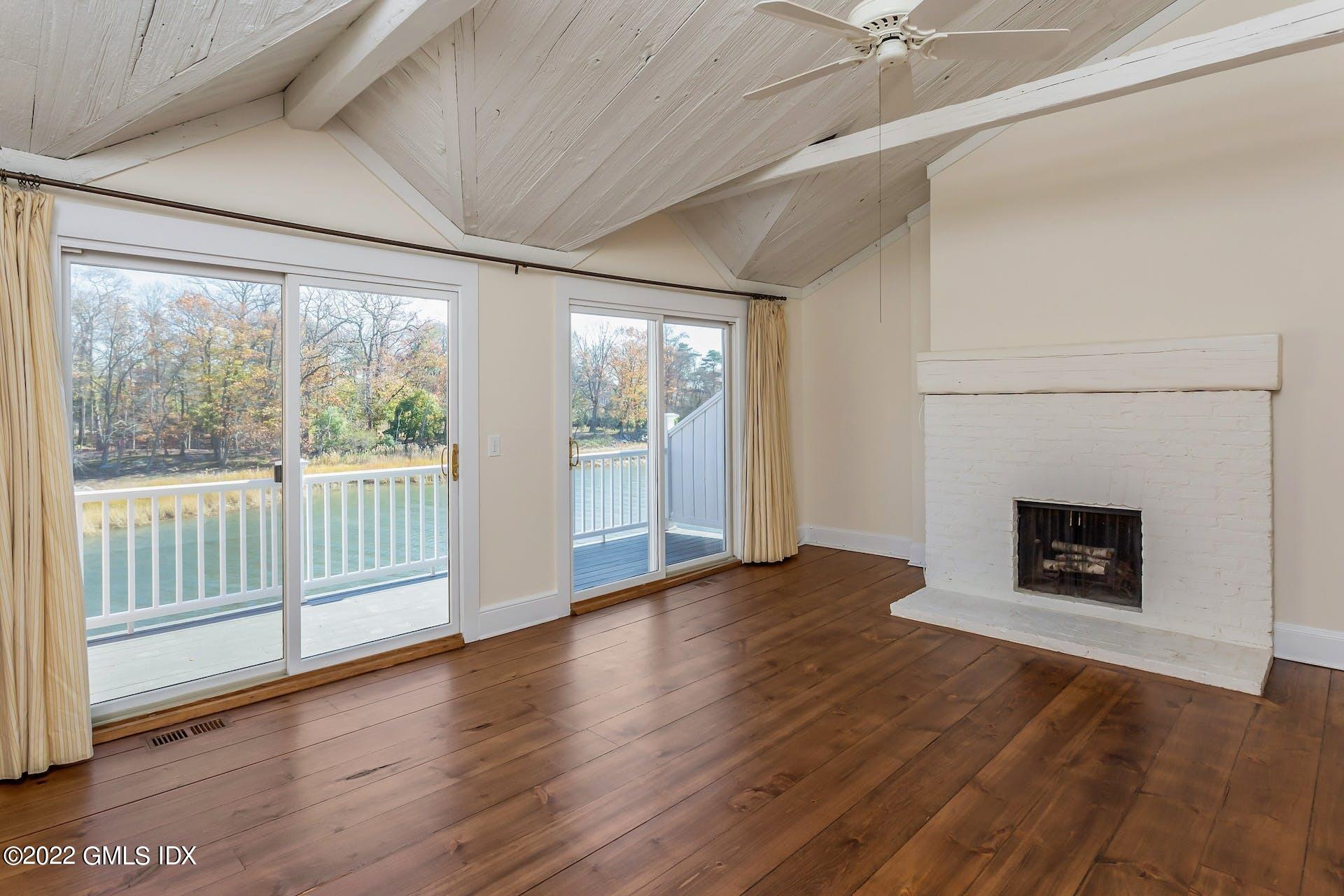 603 Steamboat Road, Unit 6 Greenwich, CT 06830 - Photo 21 of 40 an empty room with wooden floor fireplace and windows