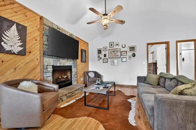 a kitchen with stainless steel appliances granite countertop a refrigerator a stove a sink dishwasher a dining table and chairs with wooden floor