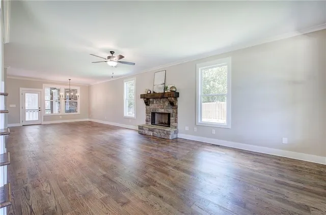 a view of an empty room with wooden floor and staircase