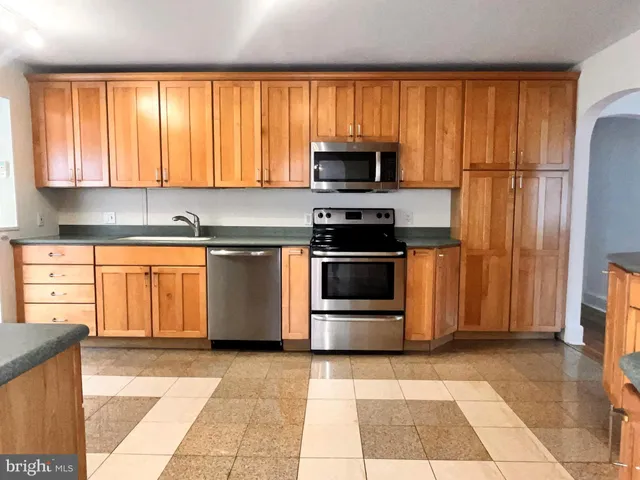 a kitchen with stainless steel appliances a stove a microwave and a sink