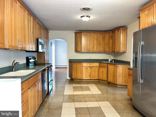 a kitchen with stainless steel appliances granite countertop a refrigerator and a sink