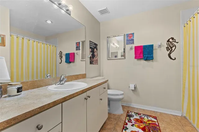 a bathroom with a sink vanity granite and toilet