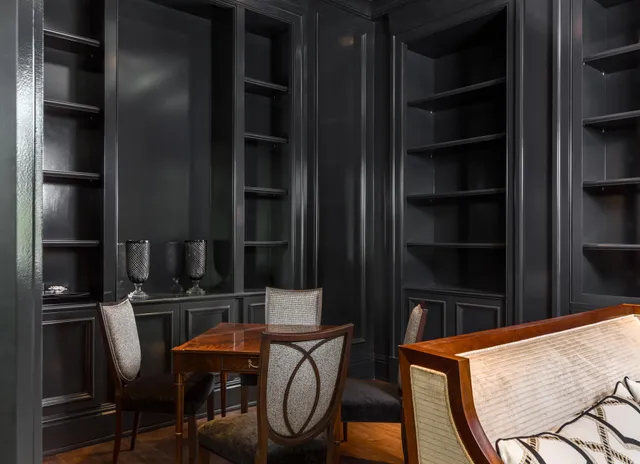a view of a dining room and livingroom with furniture wooden floor a chandelier