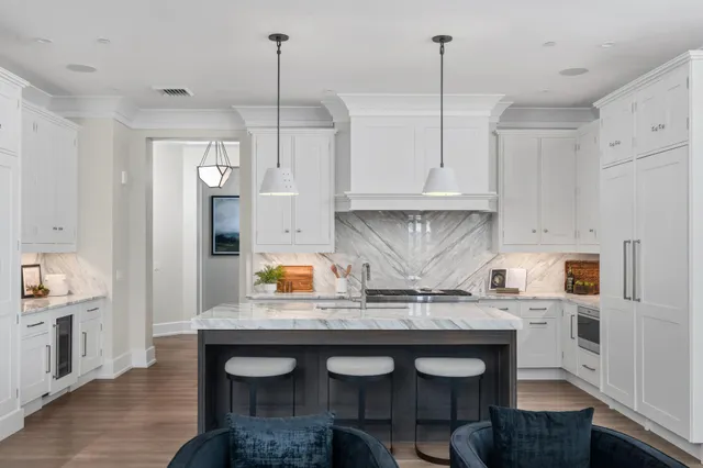 a kitchen with stainless steel appliances white cabinets and a stove top oven
