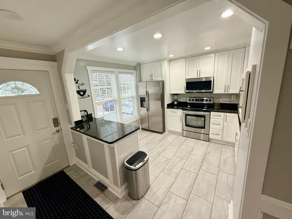 a kitchen with stainless steel appliances granite countertop a stove a sink and a refrigerator