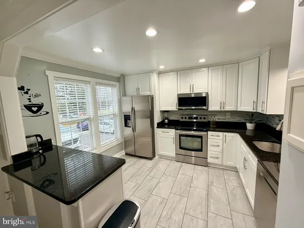 a kitchen with stainless steel appliances granite countertop a sink and a stove
