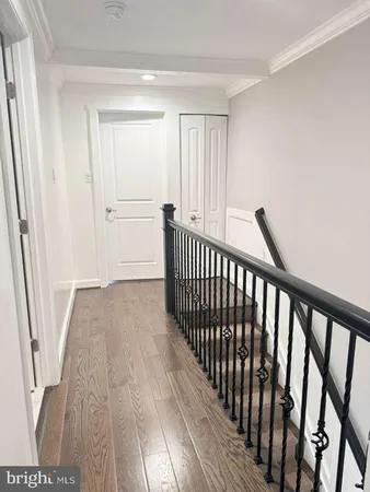 a view of a hallway with wooden floor and staircase