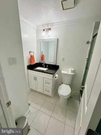 a bathroom with a granite countertop toilet sink and mirror