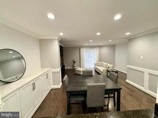 a kitchen with stainless steel appliances granite countertop a table chairs sink and cabinets
