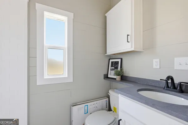 a bathroom with a toilet a sink and mirror