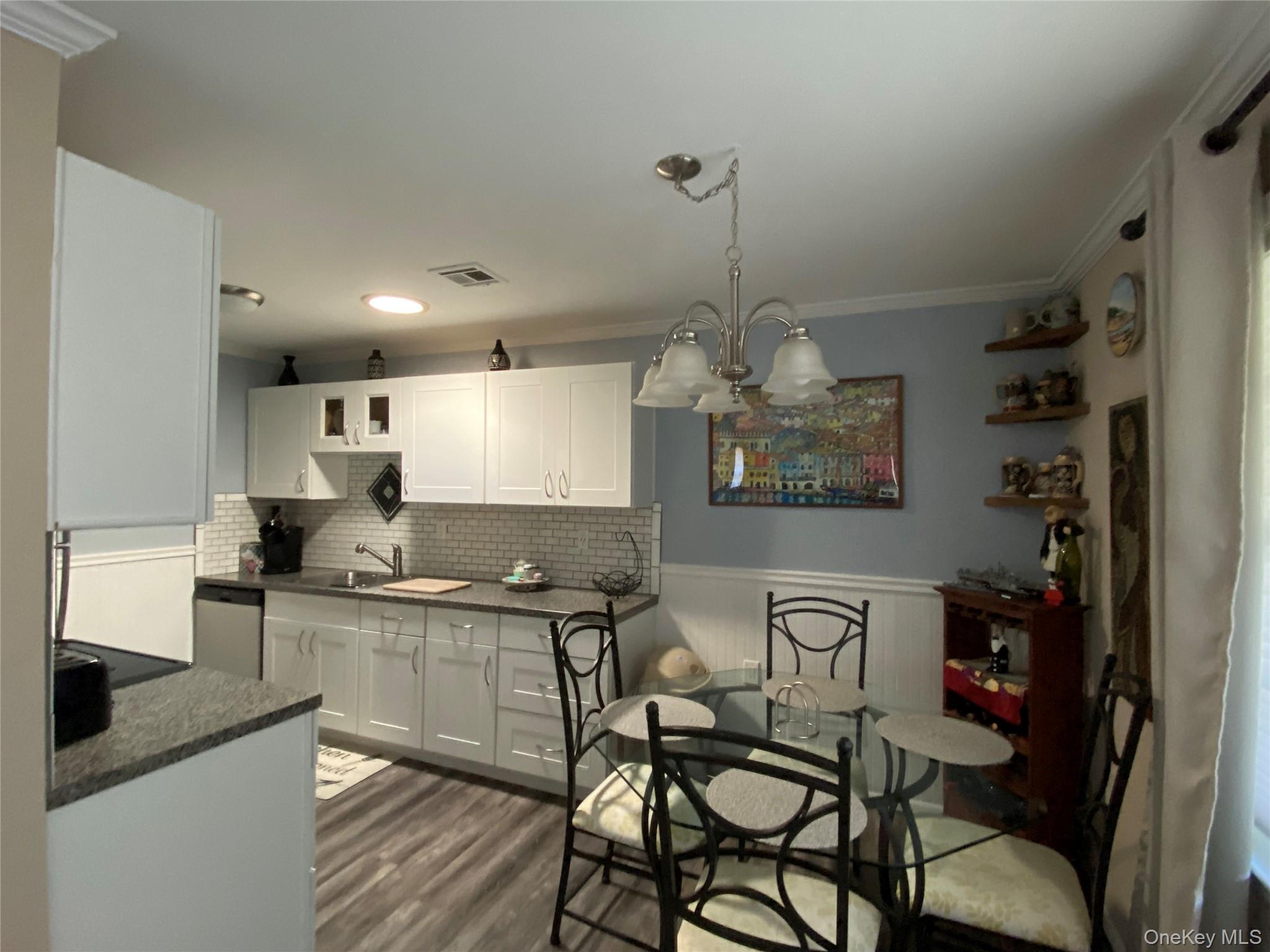 274 Berwick Court, Unit A Ridge, NY 11961 - Photo 15 of 26 a kitchen with stainless steel appliances granite countertop a sink and cabinets